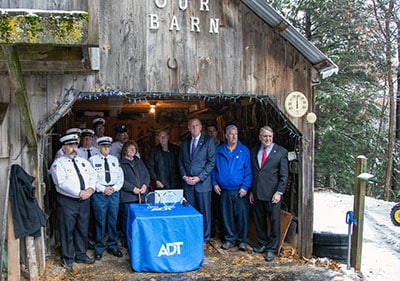 The Sunapee Fire Departmentn along with Barb & Jim Dulling pose in their barn with Tim McKinney, VP from ADT.
