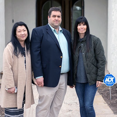 Bret and Ana Jensen with his mother Coleen stand outside their home in Spring TX