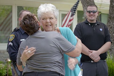 Suzanne Smith gives ADT Dispatcher Stacey Fioravanti a hug.